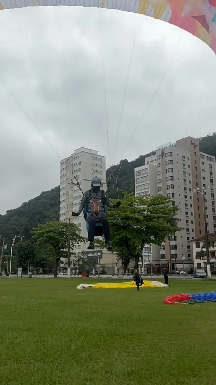 Aluno inflando a vela no gramado em frente aos prédios