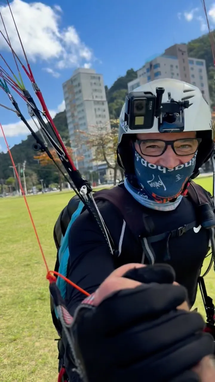 Piloto de capacete com câmera segurando as linhas antes de decolar
