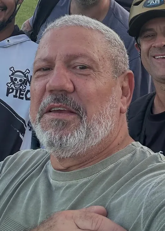 Xandão sorrindo numa selfie com a turma na praia